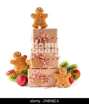 Ein Stapel Weihnachtsgeschenkboxen in handgemachtem Papier mit knusprigen Lebkuchenkeksen und heller Dekoration. Merry Christmas Concept auf weißem Hintergrund Stockfoto