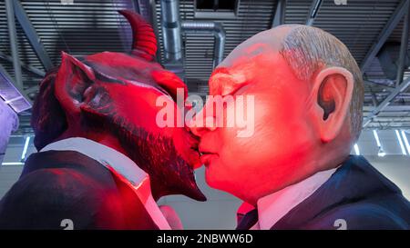 Köln, Deutschland. 14. Februar 2023. Ein Themenwagen, auf dem der russische Präsident Wladimir Putin den Teufel küsst, wird bei der Bestendigungszeremonie für die Parade am Kölner Rosenmontag in Koelnmesse enthüllt. Kredit: Rolf Vennenbernd/dpa/Alamy Live News Stockfoto