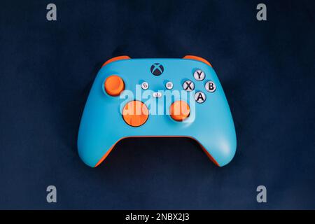 LONDON – 13. FEBRUAR 2023: Kundenspezifischer Xbox Design Lab Gaming-Controller in leuchtend orangefarbenem Blau Stockfoto