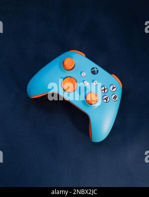 LONDON – 13. FEBRUAR 2023: Kundenspezifischer Xbox Design Lab Gaming-Controller in leuchtend orangefarbenem Blau Stockfoto