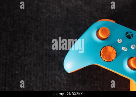 LONDON – 13. FEBRUAR 2023: Kundenspezifischer Xbox Design Lab Gaming-Controller in leuchtend orangefarbenem Blau Stockfoto