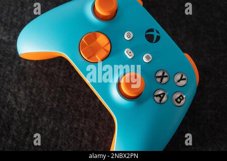 LONDON – 13. FEBRUAR 2023: Kundenspezifischer Xbox Design Lab Gaming-Controller in leuchtend orangefarbenem Blau Stockfoto