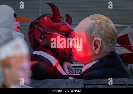 Köln, Deutschland. 14. Februar 2023. Ein Themenwagen, auf dem der russische Präsident Wladimir Putin den Teufel küsst, wird bei der Bestendigungszeremonie für die Parade am Kölner Rosenmontag in Koelnmesse enthüllt. Kredit: Rolf Vennenbernd/dpa/Alamy Live News Stockfoto