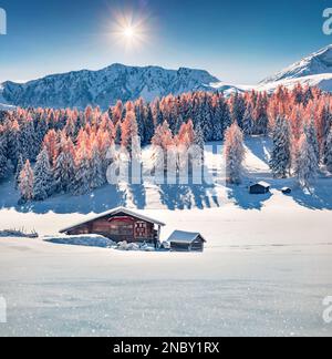Frischer Schnee, der im Sonnenlicht glitzert. Heller Blick am Morgen auf das Dorf Alpe di Siusi. Atemberaubende Winterszene der Dolomiten-Alpen. Fantastische Skilandschaft Stockfoto