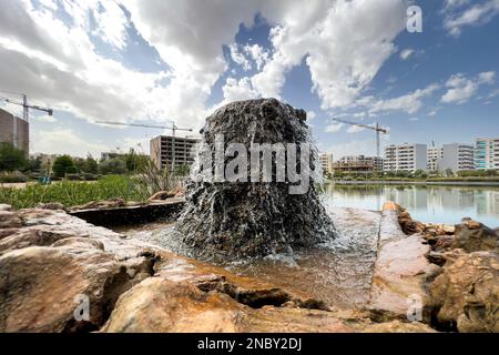 Wasser fließt aus einem felsigen Brunnen in einem öffentlichen Park Stockfoto