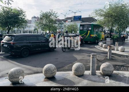 Yogyakarta, Indonesien - ca. 2023: Einwohner fahren mit verschiedenen Fahrzeugen, die an der Ampel in km 0 halten. Point Jogja in der Nähe der Malioboro Straße. Stockfoto