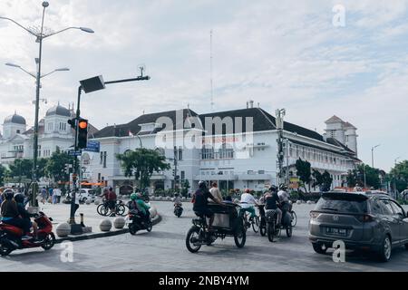 Yogyakarta, Indonesien - ca. 2023: Einwohner fahren mit verschiedenen Fahrzeugen, die an der Ampel in km 0 halten. Point Jogja in der Nähe der Malioboro Straße. Stockfoto