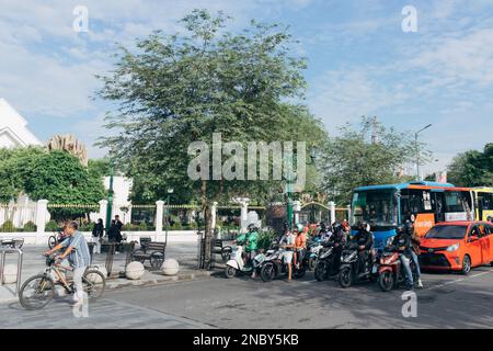 Yogyakarta, Indonesien - ca. 2023: Einwohner fahren mit verschiedenen Fahrzeugen, die an der Ampel in km 0 halten. Point Jogja in der Nähe der Malioboro Straße. Stockfoto