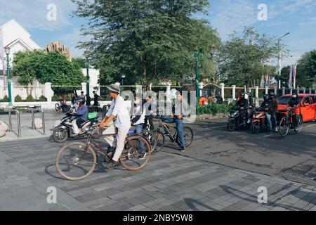 Yogyakarta, Indonesien - ca. 2023: Einwohner fahren mit verschiedenen Fahrzeugen, die an der Ampel in km 0 halten. Point Jogja in der Nähe der Malioboro Straße. Stockfoto