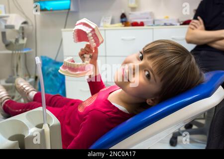 Ein Mädchen in einer Zahnarztpraxis zeigt ihr Kiefer. Medizin, Zahnheilkunde und Gesundheitswesen Stockfoto