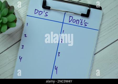 Konzept von Geboten und Verboten Schreiben Sie auf Unterlagen isoliert auf einem Holztisch. Stockfoto