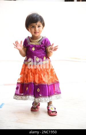 Sehr schönes Baby Girl in einem traditionellen rosafarbenen Kleid Stockfoto