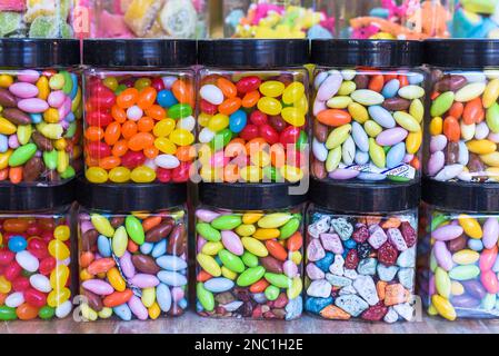 Viele bunte Süßigkeiten und Lutscher mit Kaugummi in Gläsern Stockfoto