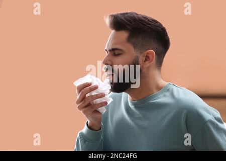 Junger Mann mit laufender Nase im Haus Stockfoto