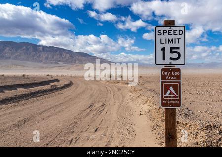 Schild warnt vor Campingbeschränkungen und Geschwindigkeitsbegrenzung von 15mph km/h. Death Valley National Park. Stockfoto