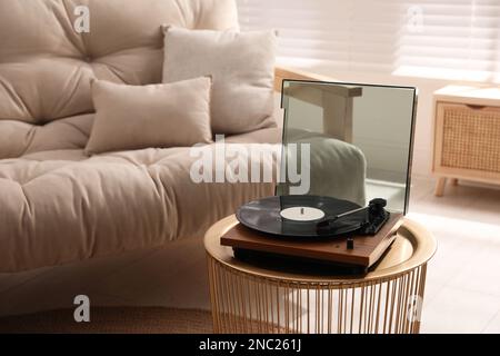 Eleganter Plattenspieler mit Vinylscheibe im Wohnzimmer Stockfoto