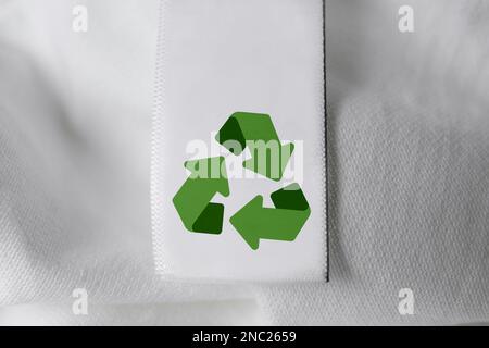 Kleidungsetikett mit Recycling-Symbol auf weißem Hemd, Nahaufnahme Stockfoto