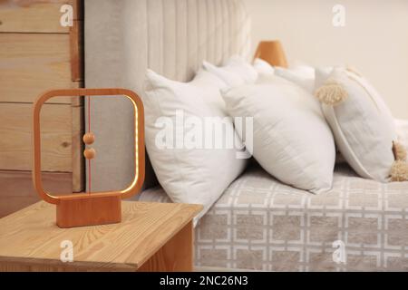 Moderne Lampe auf Nachttisch neben dem Bett im Hotel Stockfoto