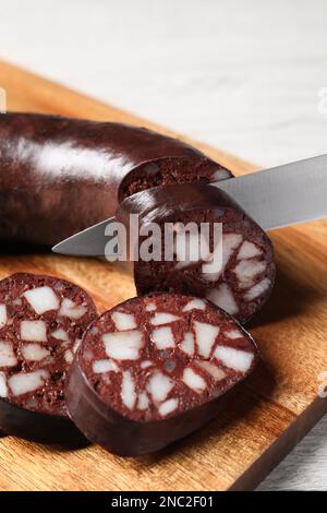 Schmackhafte Blutwurst auf Holzbrett schneiden, Nahaufnahme Stockfoto