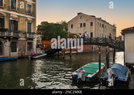 Ponte de Gheto Novo am Kanal Rio della Misericordia im Sestiere von Cannaregio mit Menschen bei Sonnenuntergang, Venedig, Veneto, Italien Stockfoto