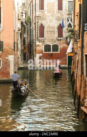 Gondeln mit Touristen auf dem Kanal Rio del Fondego dei Tedeschi zwischen den Sestieri von St. Mark und Cannaregio im Sommer, Venedig, Venetien, Italien Stockfoto