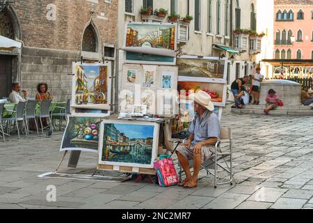 Straßenkünstler, der venezianische Ausblicke auf dem Campo Santa Sofia Platz im Sestiere von Cannaregio im Sommer in Venedig, Veneto, Italien verkauft Stockfoto