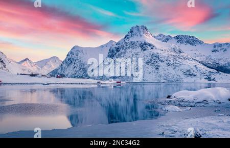 Ruhiger Sonnenaufgang im Winter über dem Polarkreis. Herrliche Morgenszene des Boosen Fjords auf Flakstadoya Island, Lofoten Inseln mit Hustinden Berg auf der Rückseite Stockfoto