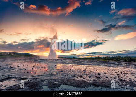 Außergewöhnlicher Sommerblick auf den Ausbruch des Großen Geysir im Haukadalur-Tal an den Hängen des Laugarfjall-Hügels. Fantastische Morgenszene von Sout Stockfoto