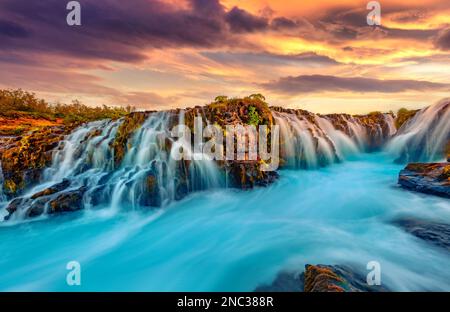 Wunderbarer Sommerblick auf den Bruarfoss Wasserfall, abgeschiedener Ort mit rauschenden blauen Gewässern. Toller Sonnenuntergang in Island, Europa. Das schöne Naturkonzept zurück Stockfoto