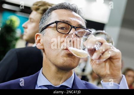 Nürnberg, Deutschland. 14. Februar 2023. Bundesminister für Landwirtschaft Cem Özdemir (Bündnis 90/die Grünen) probiert bei einer Führung durch die Biofach-Messe ein Glas Biosekt Rose. Vom 14. Bis 17. Februar 2023 werden auf der weltweit führenden Fachmesse für Biofach und der Fachmesse für Naturkosmetika VIVANESS 2.765 Aussteller aus 95 Ländern Produkte der Bio-Lebensmittel- und Naturkosmetikindustrie präsentieren. Kredit: Daniel Karmann/dpa/Alamy Live News Stockfoto