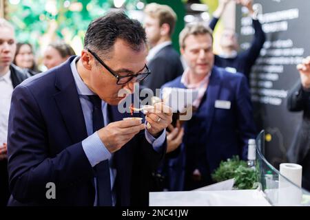 Nürnberg, Deutschland. 14. Februar 2023. Bundesminister für Landwirtschaft Cem Özdemir (M, Bündnis 90/die Grünen) versucht vegane Gyros während einer Führung durch die Biofach-Messe. Vom 14. Bis 17. Februar 2023 werden auf der weltweit führenden Fachmesse für Biofach und der Fachmesse für Naturkosmetika VIVANESS 2.765 Aussteller aus 95 Ländern Produkte der Bio-Lebensmittel- und Naturkosmetikindustrie präsentieren. Kredit: Daniel Karmann/dpa/Alamy Live News Stockfoto