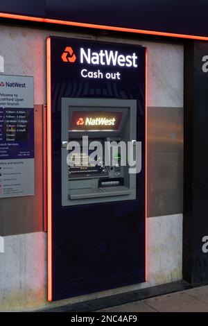 Logo und Titel der NatWest Bank sowie ein Geldautomat auf der Außenseite einer Filiale in Stratford-upon-Avon, Großbritannien. Konzept: Britisches Bankgewerbe Stockfoto