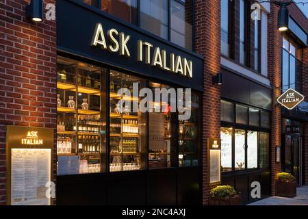Das Äußere des italienischen Restaurants Ask erstrahlte nachts mit Weinflaschen in den Fenstern und einer Speisekarte an der Wand. Bell Court, Stratford-upon-Avon, Großbritannien Stockfoto