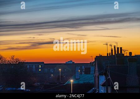 Northampton, Großbritannien. Wetter, 14. Februar 2023. Ein schöner Sonnenuntergang über den Dächern nach einem sehr nebligen Start in den Tag. Kredit: Keith J. Smith./Alamy Live News Stockfoto