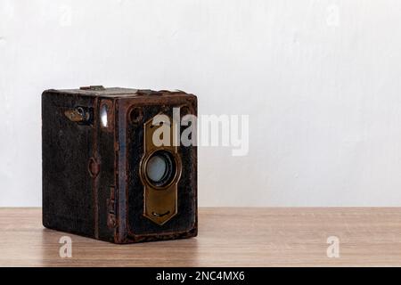 Klassische Kastenkamera mit Folienrollen auf einem Holzschreibtisch mit Kopierbereich. Stockfoto