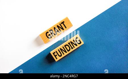Symbol für Zuschussfinanzierung. Konzeptbegriffe Zuschüsse auf Holzblöcken. Wunderschöner weißer und blauer Hintergrund. Konzept der Geschäfts- und Zuschussfinanzierung. Kopieren Sie Spac Stockfoto