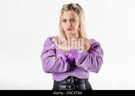 Blonde Millennials in gerippter Bluse, die isoliert auf weißem Hintergrund steht, gekreuzte Hände zeigen kein Stopp verbotene Symbol, Abstoßungsausdruck Stockfoto