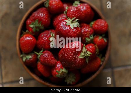 Frische Erdbeeren in einer Holzschüssel. Selektiver Fokus. Draufsicht. Stockfoto