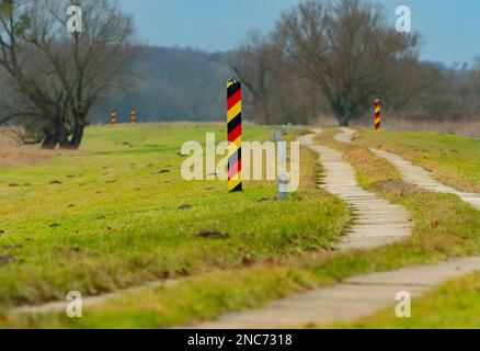 30. Januar 2023, Brandenburg, Schwedt/Oder: 30.01.2023, Schwedt/Oder. Die deutschen, schwarz-rot-goldenen Grenzposten stehen auf einem Pfad nahe Schwedt an der deutsch-polnischen Grenze der oder. Foto: Wolfram Steinberg/dpa Foto: Wolfram Steinberg/dpa Stockfoto