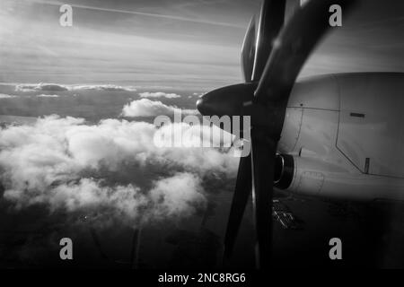 Der große Propeller eines Propellerflugzeugs, das über den Wolken fliegt Stockfoto