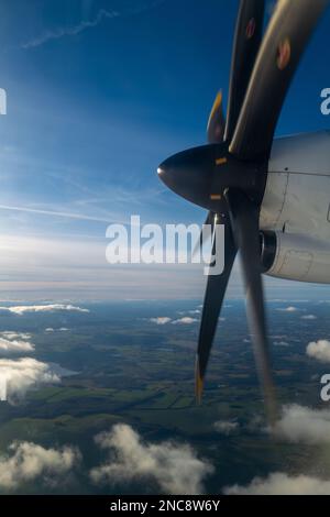 Der große Propeller eines Propellerflugzeugs, das über den Wolken fliegt Stockfoto
