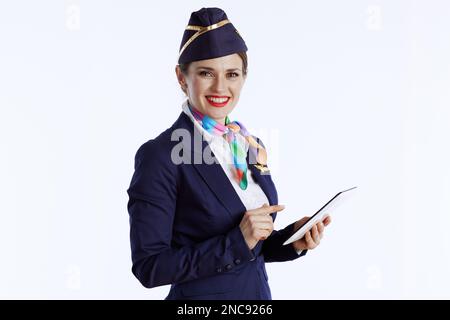 Lächelnde, elegante Stewardess, isoliert auf weißem Hintergrund, in Uniform mit Tablet-PC. Stockfoto