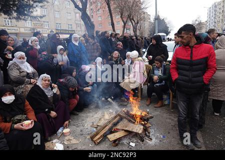 Diyarbakir, Türkei. 8. Februar 2023. Familien und Verwandte von denen, die noch in den Trümmern gefangen sind, erwärmen sich durch ein Feuer, während sie auf Nachrichten über ihre Leute vom Such- und Rettungsteam warten. 7 Gebäude in der Stadt wurden vollständig zerstört. Die Rettungsarbeiten in der Stadt wurden 9 Tage nach dem Erdbeben abgeschlossen. Die Zahl der Todesopfer erreichte 344. Es gibt fast 1000 Verletzte. In Diyarbakir gibt es insgesamt 307 Gebäude, von denen 26 zerstört werden, 25 sofort abgerissen werden müssen und 261 schwer beschädigt sind. Etwa 250.000 Menschen können ihr Zuhause nicht betreten. Sie leben entweder im Zelt CI Stockfoto