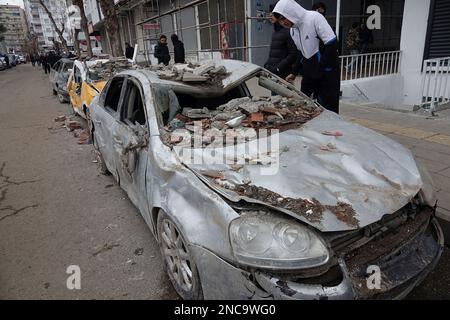 Diyarbakir, Türkei. 8. Februar 2023. Ein Auto, das von einem Gebäude zertrümmert wurde, das bei dem Erdbeben zerstört wurde. Die Autos wurden aus den Trümmern gezogen und am Straßenrand zurückgelassen. 7 Gebäude in der Stadt wurden vollständig zerstört. Die Rettungsarbeiten in der Stadt wurden 9 Tage nach dem Erdbeben abgeschlossen. Die Zahl der Todesopfer erreichte 344. Es gibt fast 1000 Verletzte. In Diyarbakir gibt es insgesamt 307 Gebäude, von denen 26 zerstört werden, 25 sofort abgerissen werden müssen und 261 schwer beschädigt sind. Etwa 250.000 Menschen können ihr Zuhause nicht betreten. Sie leben entweder in Zeltstädten oder in sicheren Unterkünften Stockfoto