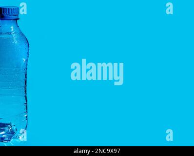Banner mit feuchter Kunststoffflasche Wasser auf blauem Hintergrund mit Kopierbereich für Text oder Design. Stockfoto