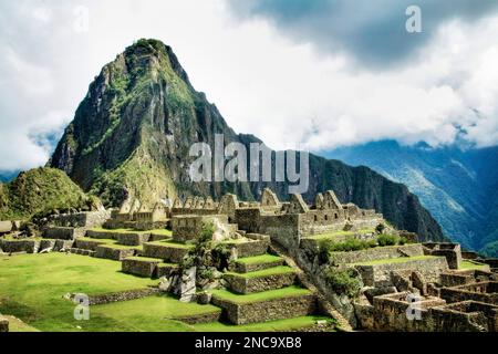 Huayna Picchu erhebt sich über die verlorene Stadt Machu Picchu in den Anden von Peru. Stockfoto