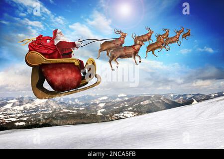 Magischer Weihnachtsabend. Weihnachtsmann mit Rentieren, die am Himmel fliegen Stockfoto