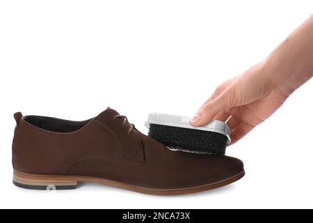 Eine Frau putzt Wildlederschuhe auf weißem Hintergrund, Nahaufnahme. Schuhpflegezubehör Stockfoto