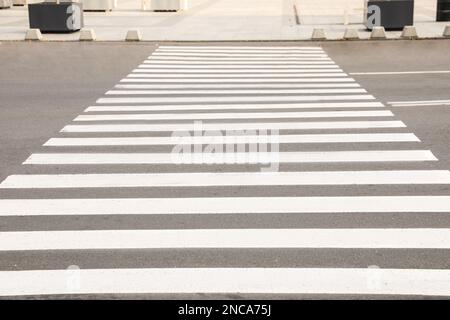 Weißer Fußgängerübergang auf einer leeren Straße Stockfoto