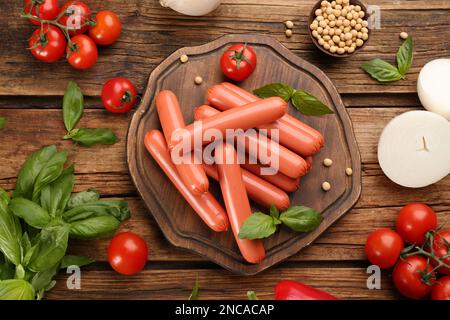 Frische rohe vegetarische Würste, Sojabohnen und Gemüse auf Holztisch, flach liegend Stockfoto